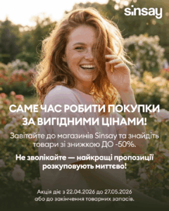 Усміхнена жінка з рудим волоссям серед квітів у саду; поверх неї український рекламний текст про знижки до 50% Sinsay.