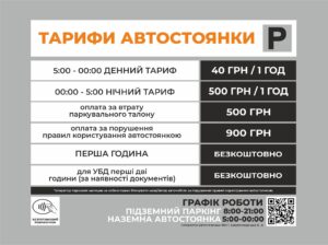 White sign with orange Ukrainian text 'ТАРИФИ АВТОСТОЯНКИ' and a grey 'P' icon indicating parking rates for a lot.