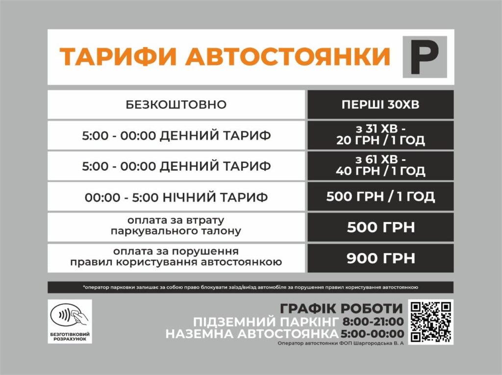 Parking tariff board in Ukrainian with white left column and black right column listing rates and hours; header in orange reads 'ТАРИФИ АВТОСТОЯНКИ'.